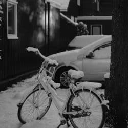 Snow covered bikeand car near building - Photo by Haberdoedas on Unsplash